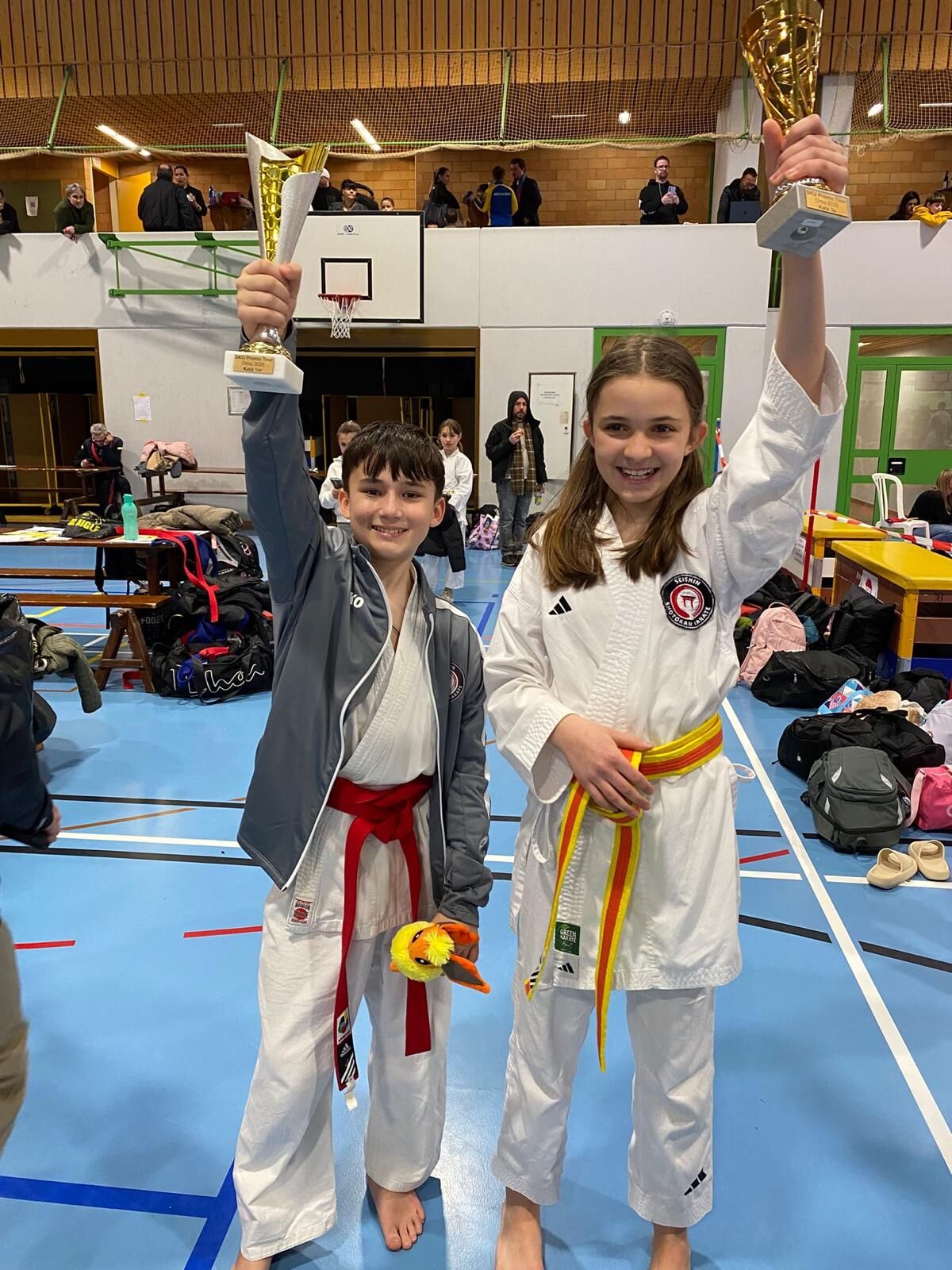 Junge Karateka mit Pokal