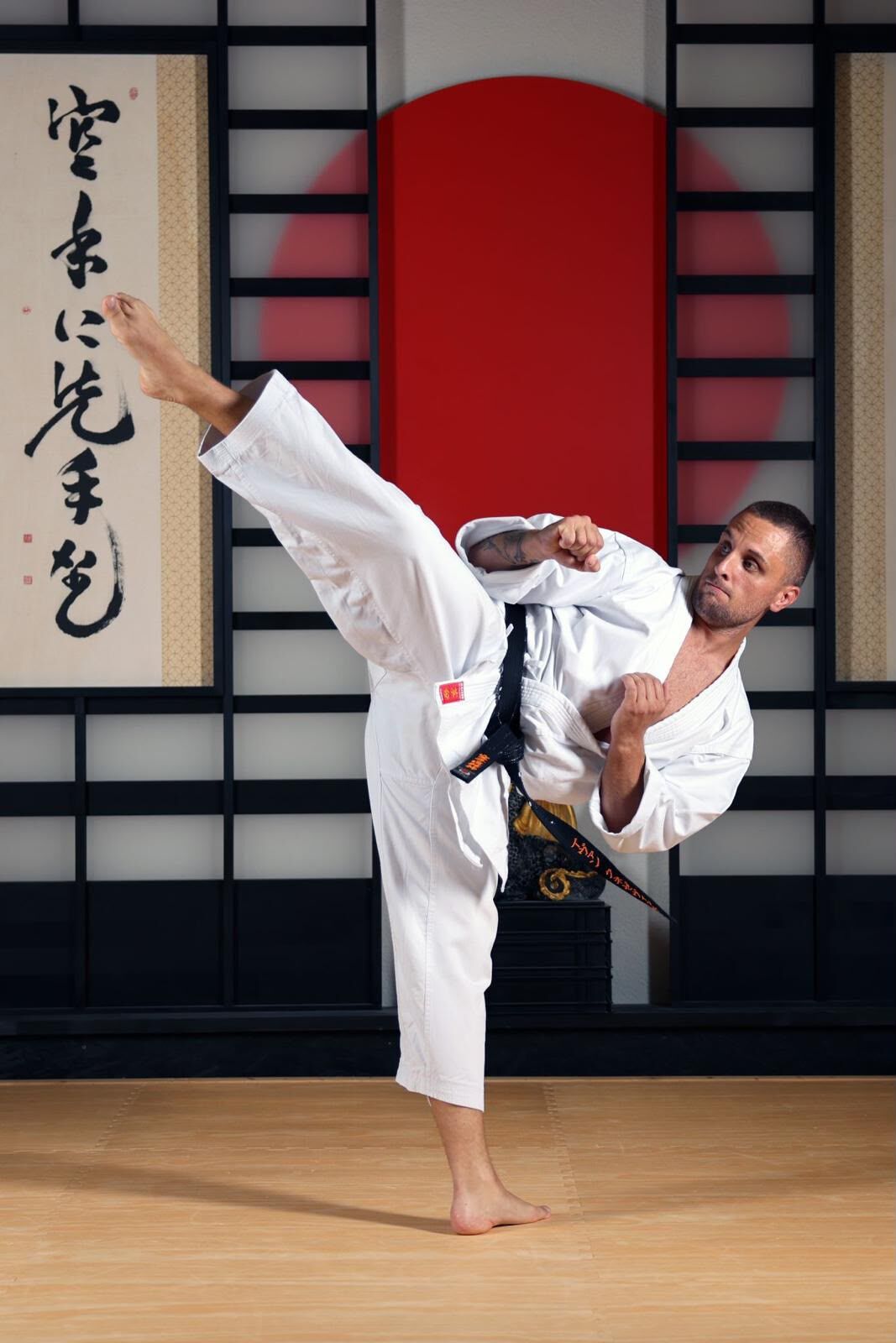 Karateka bei einem hohen Fusstritt im Dojo